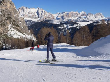 Alp Kayakçıları Güzel Karlı bir yamaçtan iniyor ve İtalyan Alpleri Dolomitleri Dağları 'nın karla kaplı manzarası var..