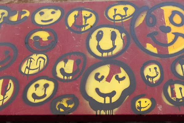 Group of Yellow and Red Smiley Faces Painted on a Wall