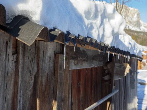 白雪覆盖的山林小屋的屋顶 结冰落水 — 图库照片