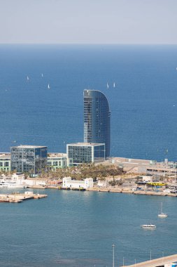 Barcelona Limanı yakınlarında aynalı pencereleri olan bir gökdelen manzarası ve İspanya 'nın Denizde Çok sayıda yelkenli teknesi.