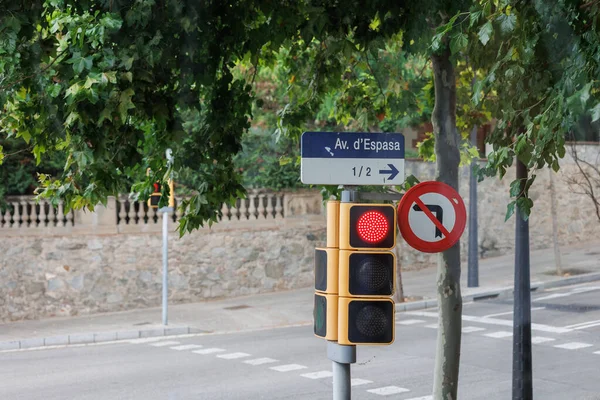 Traffic Light on Red and Street Sign displaying dEspasa Street in Barcelona, Spain