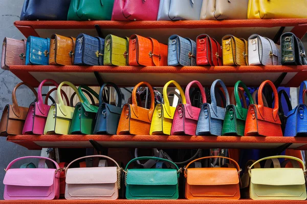 Små Kvinnors Färgglada Handväskor Olika Typer Som Hänger Ett Bildställ Royaltyfria Stockbilder