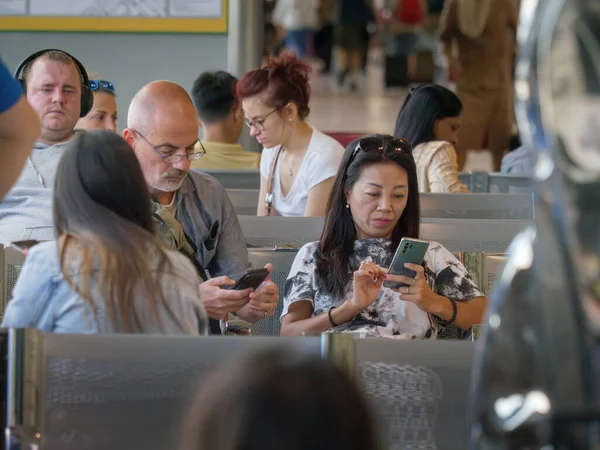 Nsanlar Havaalanından Kalkmak Için Oturmuş Akıllı Telefonlarıyla Vakit Geçiriyorlar — Stok fotoğraf