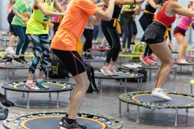 Single Rebounder Workout - People doing Fitness Exercise in Class at Gym with Music and Teacher on Stage.