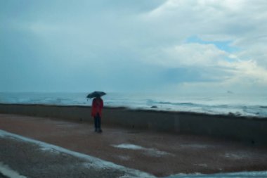 Livorno, Italy - march 29 2024: Solitary Figure with Umbrella Distorted by Raindrops on a Rainy day. clipart