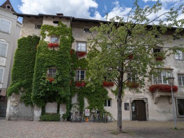 Historic House in Bressanone with Colorful Flowers and Ivy, Italy. clipart