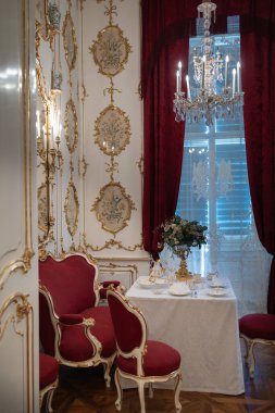 Avusturya, Viyana 'daki Schnbrunn Sarayı' nda öğleden sonra çayı için çiçek desenli goblen ve kristal şamdanlı şık yemek odası.