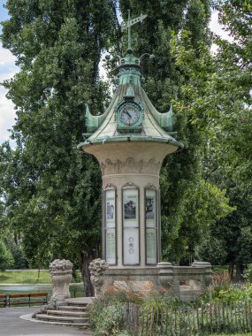 Avusturya 'daki Viyana Stadtpark' ın verimli yeşilliğinin ortasında saat kulesi.