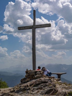 Koronlar Zirvesi 'nde Büyük Tahta Haç ve İtalya' nın manzarasına hayran kalan bir çift..