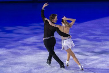 Buz pateni pistinde sanatsal ve teknik performans sergileyen çift.