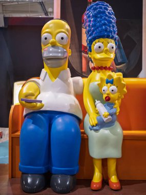 Simpsonlar ailesi, Homer, Marge ve Maggie 'nin heykeli turuncu bir kanepede.
