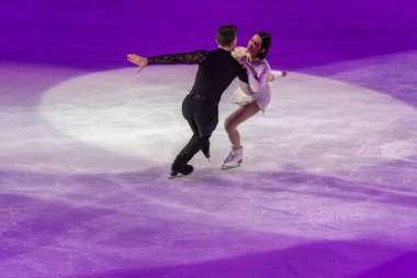 Buz pateni pistinde sanatsal ve teknik performans sergileyen çift.