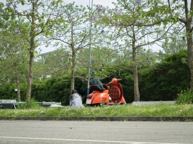 Park etmiş Orange Scooter ve yalnız kızlar ağaçların arasına..