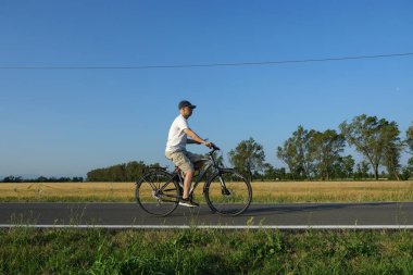 Açık Mavi Gök Altında Bisiklet Sürme, Parma 'da Sakin Bir Kır Yolunda Bisiklet Sürme, İtalya.