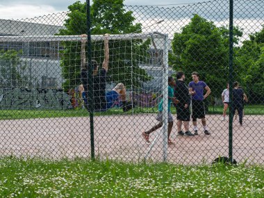 İnsanlar Zincir Çitinin Arkasındaki Park 'ta Futbol Hedefinin Yakınında Toplanıyor.