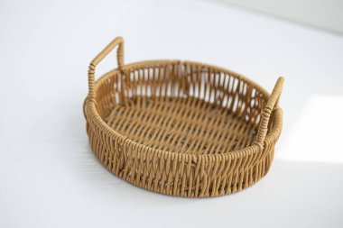 Beyaz arkaplanda yuvarlak hasır sepet.