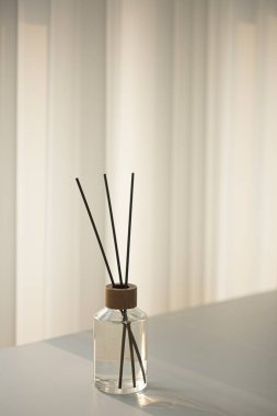 Beyaz masadaki aromatik cam şişesi.