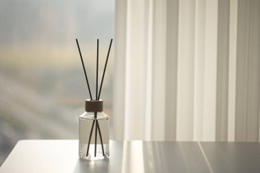 Beyaz masadaki aromatik cam şişesi.