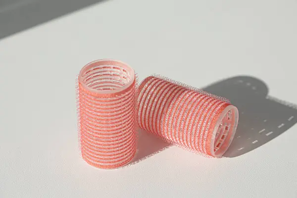 Beyaz arkaplanda izole edilmiş pembe saç ruloları