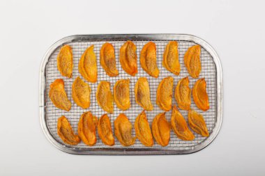 Beyaz arkaplanda kurumuş hurma parçaları.