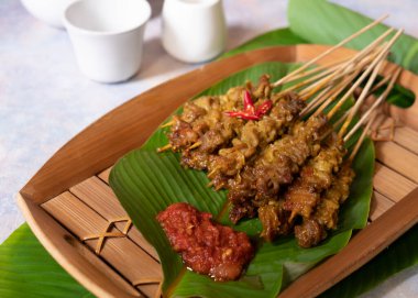 Sate us ya da tavuk bağırsakları satay. Geleneksel Endonezya sokak yemekleri. Muz yaprağı ve geleneksel bambu tabağında. Seçici Odaklanma