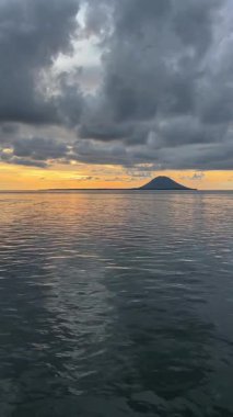 Tropikal sulardaki okyanus volkanı üzerinde düşük Altın Gün batımı Hızı