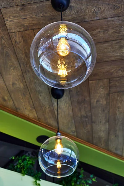 カフェの天井には照明灯がついています ガラスのランプシェードと白熱電球 — ストック写真