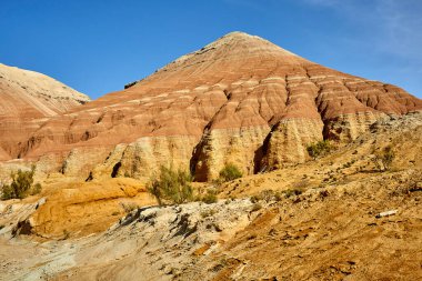 Kazakistan 'daki Altyn Emel Ulusal Parkı' nda su erozyonu izleri olan kırmızı kumtaşı dağı manzarası