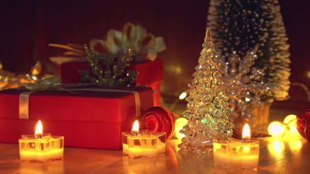 Rote Geschenkschachtel Und Kerzenschein Auf Einem Holztisch Für Weihnachten Und — Stockvideo