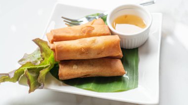 Beyaz bir tabakta kızarmış böreklerin yakın çekimi..