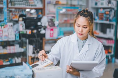 Pharmacist checking Checks Inventory of Medicine, Drugs, Vitamins with tablet and checking patient's prescription in modern pharmacy.
