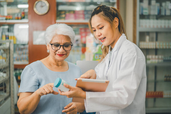 Фармацевт дает советы и советы пациентам, которые приходят покупать лекарства, лекарства, витамины, в соответствии с рецептами в современных аптеках.