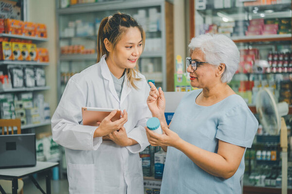 Фармацевт дает советы и советы пациентам, которые приходят покупать лекарства, лекарства, витамины, в соответствии с рецептами в современных аптеках.