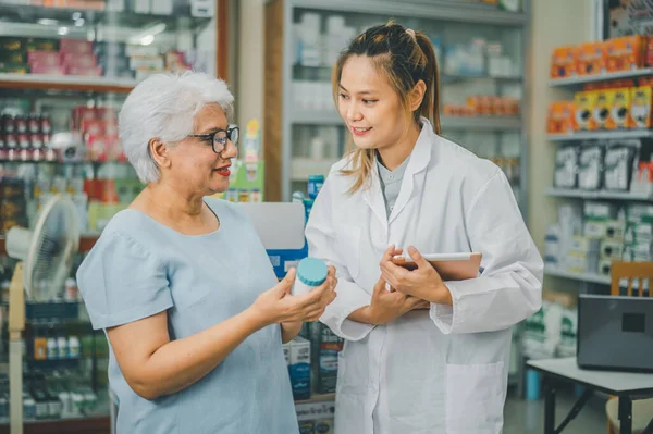Pharmacist giving advice And advice for patients who come to buy Medicine, Drugs, Vitamins products, according to prescriptions in modern pharmacies.