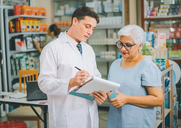 Pharmacist giving advice And advice for patients who come to buy Medicine, Drugs, Vitamins products, according to prescriptions in modern pharmacies.