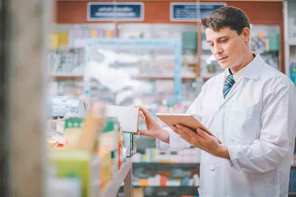 Pharmacist checking Checks Inventory of Medicine, Drugs, Vitamins with tablet and checking patient\'s prescription in modern pharmacy.