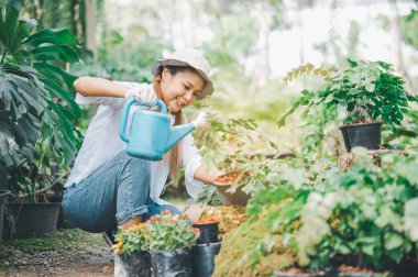 Young women doing hobbies taking care of plants, watering, shoveling flowers. In the garden during the break from work
