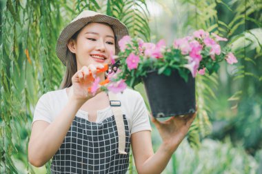 Young women doing hobbies taking care of plants, watering, shoveling flowers. In the garden during the break from work