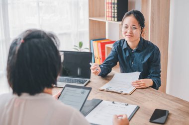 İK yöneticileri, iş başvurusu formunun özgeçmişini dolduran iş başvurularını şirket olarak kabul etmeyi düşünen iş başvurularıyla görüşüyor.