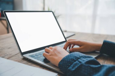 İş kadını iş yerinde dizüstü bilgisayarında yazıyor, internette arıyor ya da işlem yapıyor ve finans işleriyle uğraşıyor..