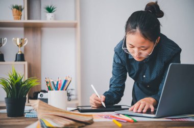 Graphic designer architects who work with laptops and color comparison tables for design work.	