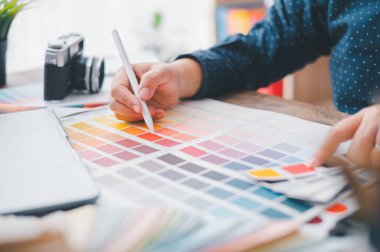 Graphic designer architects who work with laptops and color comparison tables for design work.	