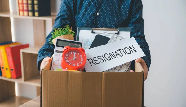 stock image Female firm employee leaving the office with cardboard boxes containing office supplies and personal items after quitting to find a new job, being fired, or being fired from the company.