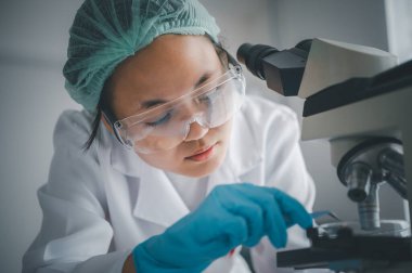 Female researchers are experimenting with pipette dropping a sample into a test tube in an experiment research in laboratory..	