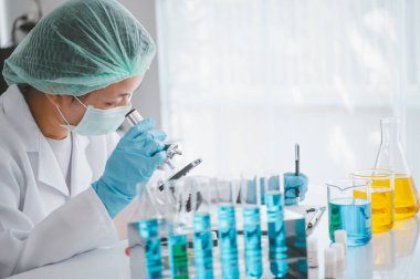 Female researchers are experimenting with pipette dropping a sample into a test tube in an experiment research in laboratory..	