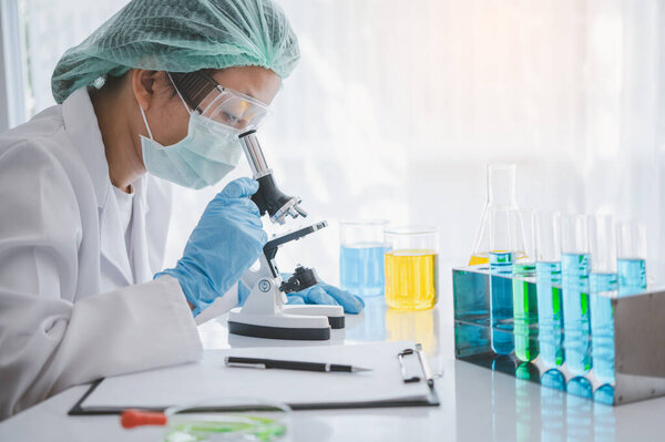 женщина-исследователь, изучающая микроскоп в медицинской лаборатории. Медицинская экспериментальная концепция
