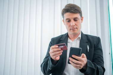 İş adamının elinde bir kredi kartı var, dijital işlemlerle fırsatların kilidini açıyor ve finansal tercihleri kavrıyor