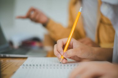 Ödev yapan genç üniversite öğrencileri, işbirliği yapan araştırma planı kavramları ve stratejileri tartışıyor. Dizüstü bilgisayarlarda ve tablet bilgisayarlarda sunumları hazırlayın.