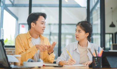 Ödev yapan genç üniversite öğrencileri, işbirliği yapan araştırma planı kavramları ve stratejileri tartışıyor. Dizüstü bilgisayarlarda ve tablet bilgisayarlarda sunumları hazırlayın.