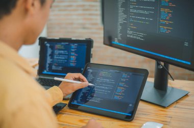 Yazılım şirketinin ofisinde kodlama, yazılım geliştirme ve web tasarımı üzerine çalışan genç bir programcı. Teknoloji geliştirme kavramı